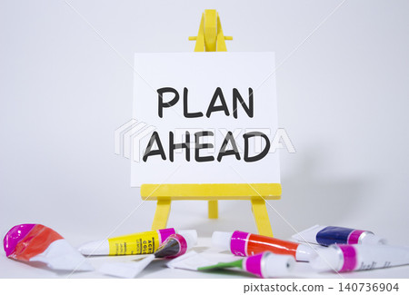 Plan ahead symbol. Wooden blocks with words Plan ahead. Beautiful white background with paints and easel. Business and Plan ahead concept. Copy space. Plan ahead symbol. Wooden blocks with words Plan ahead. Beautiful white background with paints and easel. Business and Plan ahead concept. Copy space. 140736904