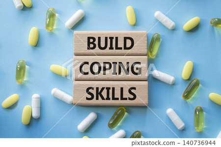 BUILD COPING SKILLS symbol. Concept words BUILD COPING SKILLS on wooden blocks. Beautiful blue background with pills. Healthcare and BUILD COPING SKILLS concept. Copy space. BUILD COPING SKILLS symbol. Concept words BUILD COPING SKILLS on wooden blocks. Beautiful blue background with pills. Healthcare and BUILD COPING SKILLS concept. Copy space. 140736944