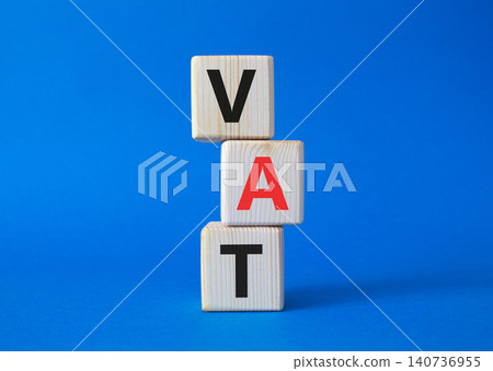 VAT - Value Added Tax symbol. Wooden cubes with word VAT. Beautiful blue background. Business and Value Added Tax concept. Copy space. 140736955