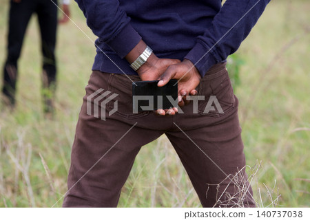close up of young man's hands holding a mobile phone in the back close up of young man's hands holding a mobile phone in the back 140737038