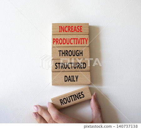Increase productivity through structured daily routines symbol. Concept words increase productivity through structured daily routines on wooden blocks. Businessman hand. Beautiful white background. 140737138