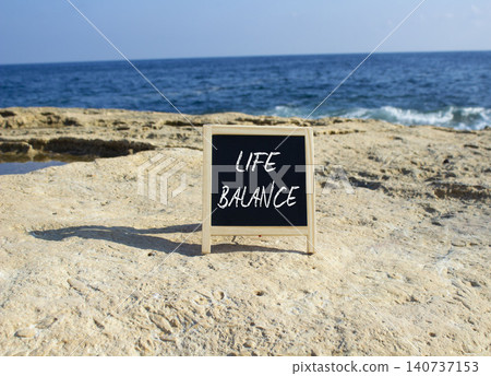 Life Balance symbol. White blackboard with Concept words Life Balance. Beautiful sea background. Business and Life Balance concept. Copy space. Life Balance symbol. White blackboard with Concept words Life Balance. Beautiful sea background. Business and Life Balance concept. Copy space. 140737153