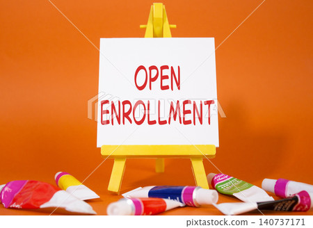 Open Enrollment symbol. Wooden blocks with words Open Enrollment. Beautiful orange background with paints and easel. Business and Open Enrollment concept. Copy space. Open Enrollment symbol. Wooden blocks with words Open Enrollment. Beautiful orange background with paints and easel. Business and Open Enrollment concept. Copy space. 140737171