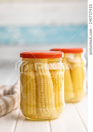 Jars of Preserved Corn Cobs With Orange Lids on a Bright Kitchen Table 140737410