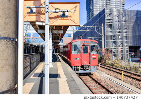 The red train approached the platform to take up passengers at Kumamoto Station. The red train approached the platform to take up passengers at Kumamoto Station. 140737427