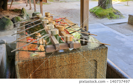 Japanese wooden dipper prepares for people who visit the shrine for clean mouth, hand, face. Japanese wooden dipper prepares for people who visit the shrine for clean mouth, hand, face. 140737497