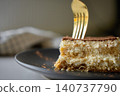 Tiramisu slice with a fork in soft cream layers and cocoa topping 140737790