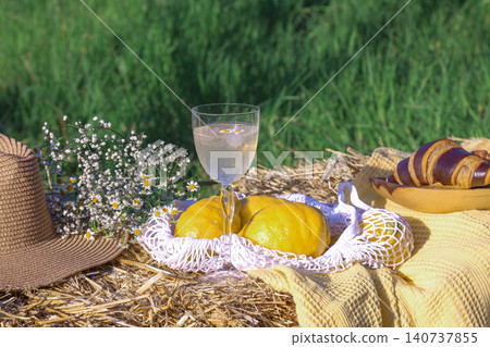 Champagne glass with peaches and croissant on straw bale Champagne glass with peaches and croissant on straw bale 140737855