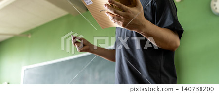 The teacher's hands as they read materials in class The teacher's hands as they read materials in class 140738200