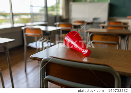A red megaphone placed on a desk in a classroom A red megaphone placed on a desk in a classroom 140738282