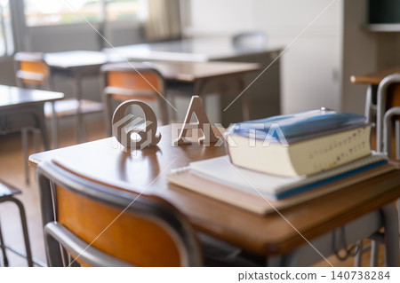 The letters "QA" and textbooks placed on a school desk. The letters "QA" and textbooks placed on a school desk. 140738284