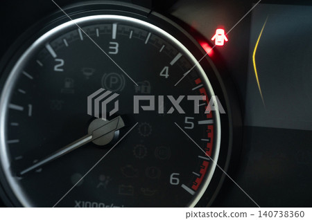 Car dashboard light indicates an alert for the driver during a trip Car dashboard light indicates an alert for the driver during a trip 140738360