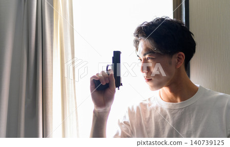 A young Japanese man with a gun 140739125