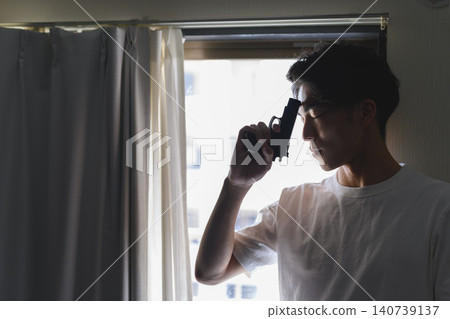 一名男子持槍倚靠在窗邊。 140739137
