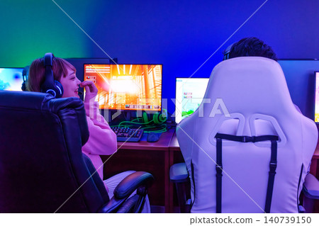 Men and women playing in a gaming room Men and women playing in a gaming room 140739150