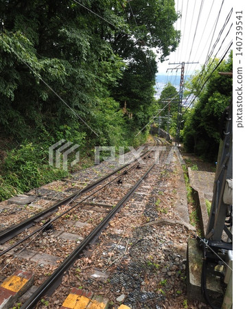 An aerial snapshot overlooking the incredibly steep incline of the Ikoma Cable Car, surrounded by the fresh greenery of early summer. 140739541