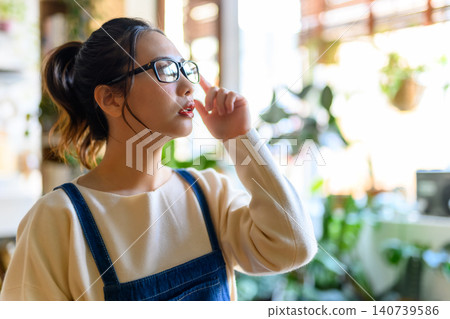 一位三十多歲的日本女性正在調整眼鏡。 140739586