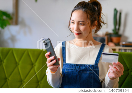 A young Japanese woman with a smartphone and a card A young Japanese woman with a smartphone and a card 140739594