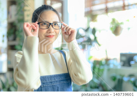 一位三十多歲的日本女性，戴著眼鏡，微笑。 140739601