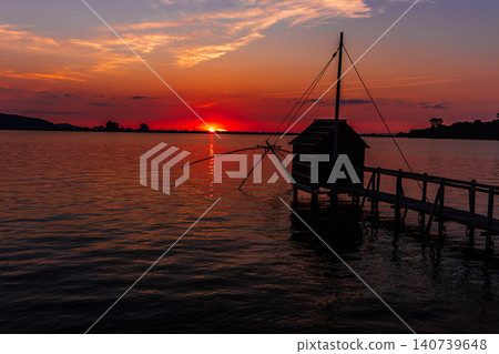 夕陽西下，多哥湖籠罩在一片絢麗的色彩中，呈現出寧靜的傍晚景色。 140739648