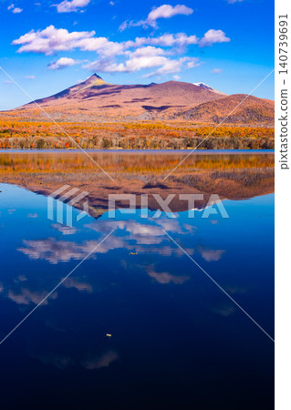 The clear autumn sky and the reflection of the autumn leaves in the water The clear autumn sky and the reflection of the autumn leaves in the water 140739691