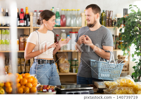 Young man and woman quarreling in grocery store Young man and woman quarreling in grocery store 140739719