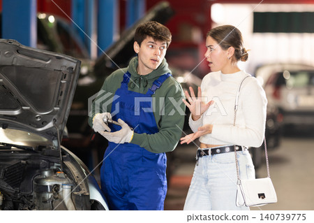 woman tells a mechanic about her car 140739775
