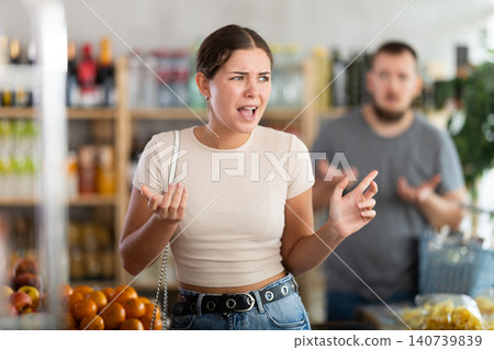 Young man quarrels with woman in grocery store Young man quarrels with woman in grocery store 140739839
