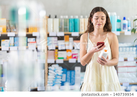 Girl scan barcode on emollient cream in pharmacy Girl scan barcode on emollient cream in pharmacy 140739934