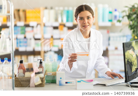 In sales area of pharmacy, young woman consultant offer and sells pills In sales area of pharmacy, young woman consultant offer and sells pills 140739936