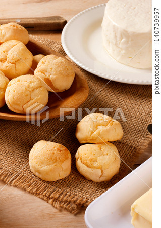 Traditional cheese bread served with white cheese and butter on a jute cloth, highlighting homemade Brazilian cuisine. Traditional cheese bread served with white cheese and butter on a jute cloth, highlighting homemade Brazilian cuisine. 140739957