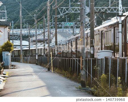 A Nose Railway Myoken Line train passing through a residential area in the early morning. A Nose Railway Myoken Line train passing through a residential area in the early morning. 140739968