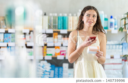 woman scans a package of pills on her phone 140739996