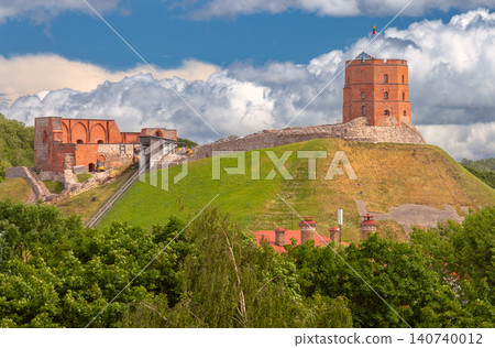 View of Gediminas Tower and the remains of the Upper Castle on Castle Hill in Vilnius beneath dramatic clouds on a summer day. View of Gediminas Tower and the remains of the Upper Castle on Castle Hill in Vilnius beneath dramatic clouds on a summer day. 140740012