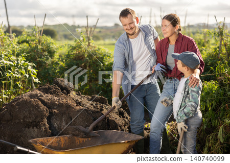 Family of farmers working with compost 140740099