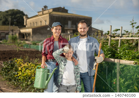 Family of farmers standing in the garden Family of farmers standing in the garden 140740100