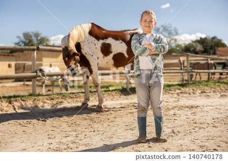 Boy posing in paddock with horse Boy posing in paddock with horse 140740178