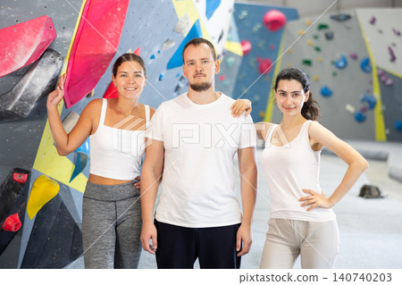Portrait of three athletic people in climbing gym Portrait of three athletic people in climbing gym 140740203