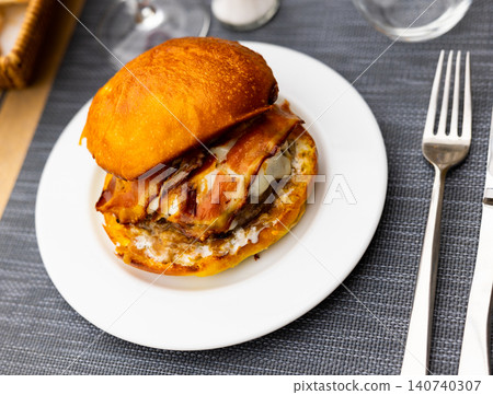 Cheeseburger with beef patty and fried bacon slices in bun Cheeseburger with beef patty and fried bacon slices in bun 140740307