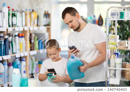 Dad and son scan barcode on packaging of laundry conditioner Dad and son scan barcode on packaging of laundry conditioner 140740403