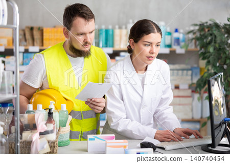 Builder client came to girl pharmacist with medical prescription Builder client came to girl pharmacist with medical prescription 140740454