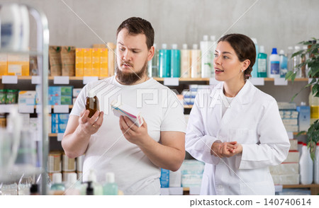 Man chooses syrup and pills with help of pharmacist Man chooses syrup and pills with help of pharmacist 140740614