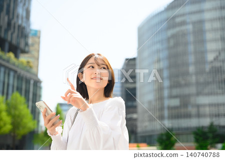 Woman holding smartphone, pointing to confirm Woman holding smartphone, pointing to confirm 140740788