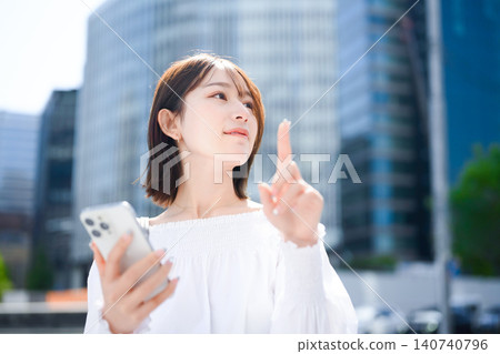 Woman holding a smartphone, pointing Woman holding a smartphone, pointing 140740796