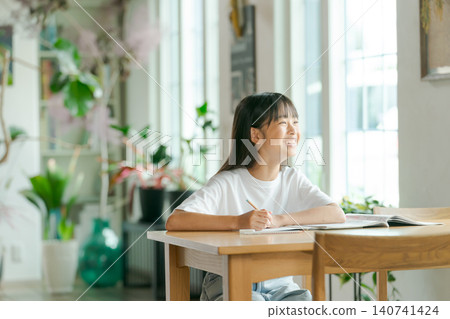 Elementary school girl studying in the living room 140741424
