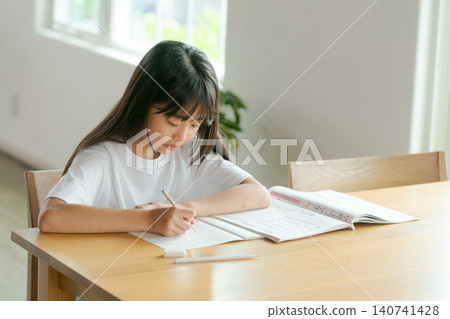 Elementary school girl studying in the living room Elementary school girl studying in the living room 140741428