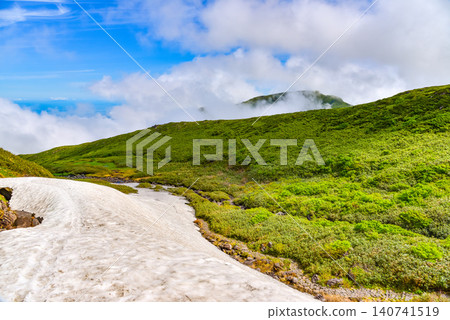 A clear summer day: A vast, uninhabited snowfield stretches out near Mount Chokai and Sai-no-Kawara. 140741519