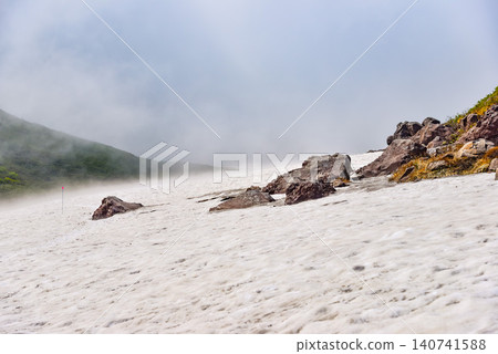 Summer at Mount Chokai: The snow-covered plains of Sai-no-Kawara and the rugged rocky landscape are obscured by rising clouds. Summer at Mount Chokai: The snow-covered plains of Sai-no-Kawara and the rugged rocky landscape are obscured by rising clouds. 140741588