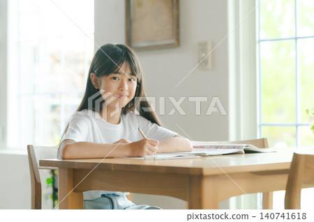 Elementary school girl studying in the living room Elementary school girl studying in the living room 140741618