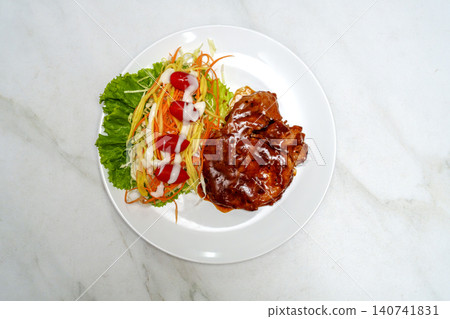 Grilled chicken steak with glossy sauce and fresh vegetable salad on a white plate. Top view of a healthy meal with carrots, lettuce, and tomatoes over a marble background. Delicious food concept. Grilled chicken steak with glossy sauce and fresh vegetable salad on a white plate. Top view of a healthy meal with carrots, lettuce, and tomatoes over a marble background. Delicious food concept. 140741831
